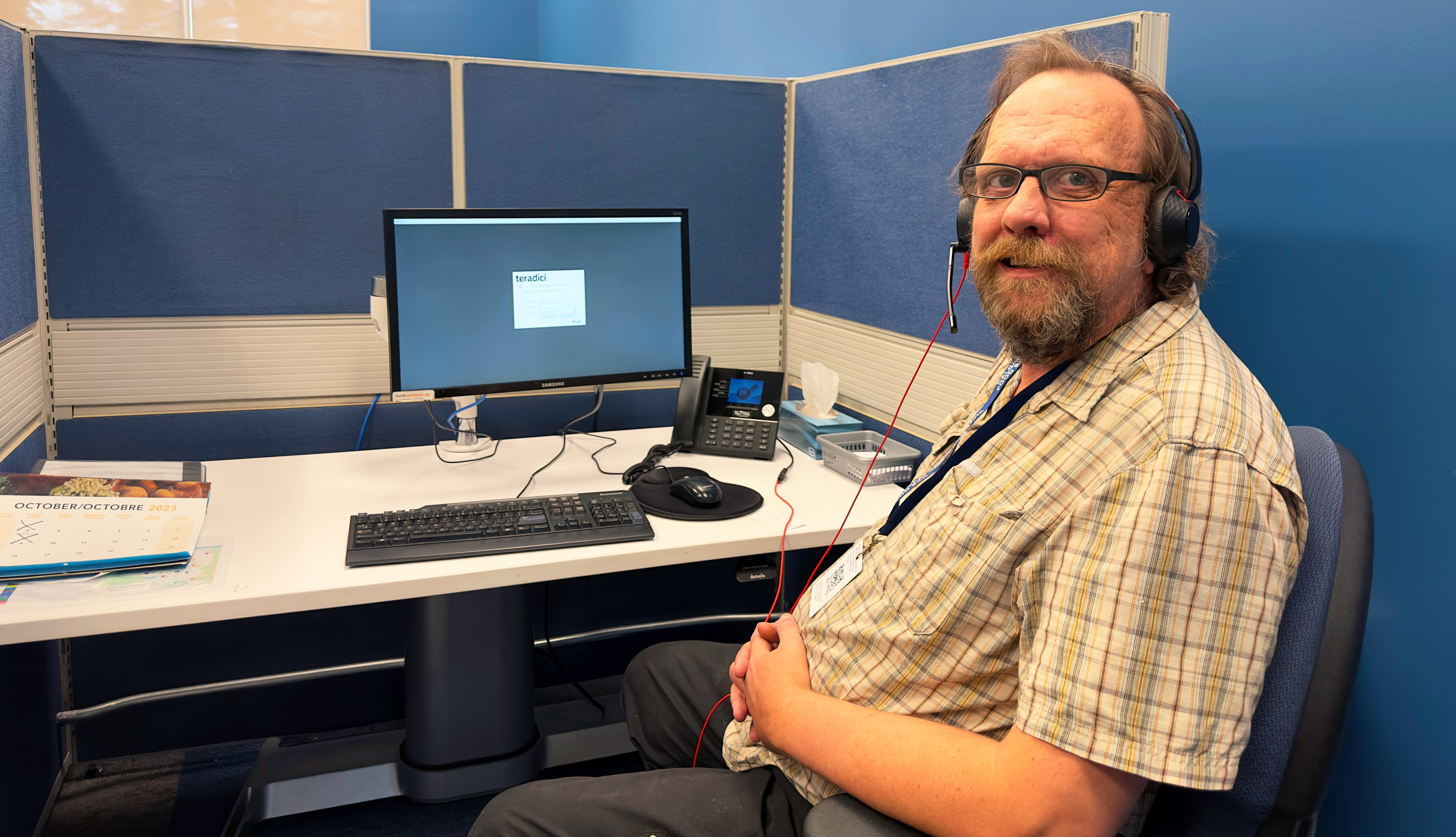 Steve sitting at his desk in the call centre at the Calgary Food Bank