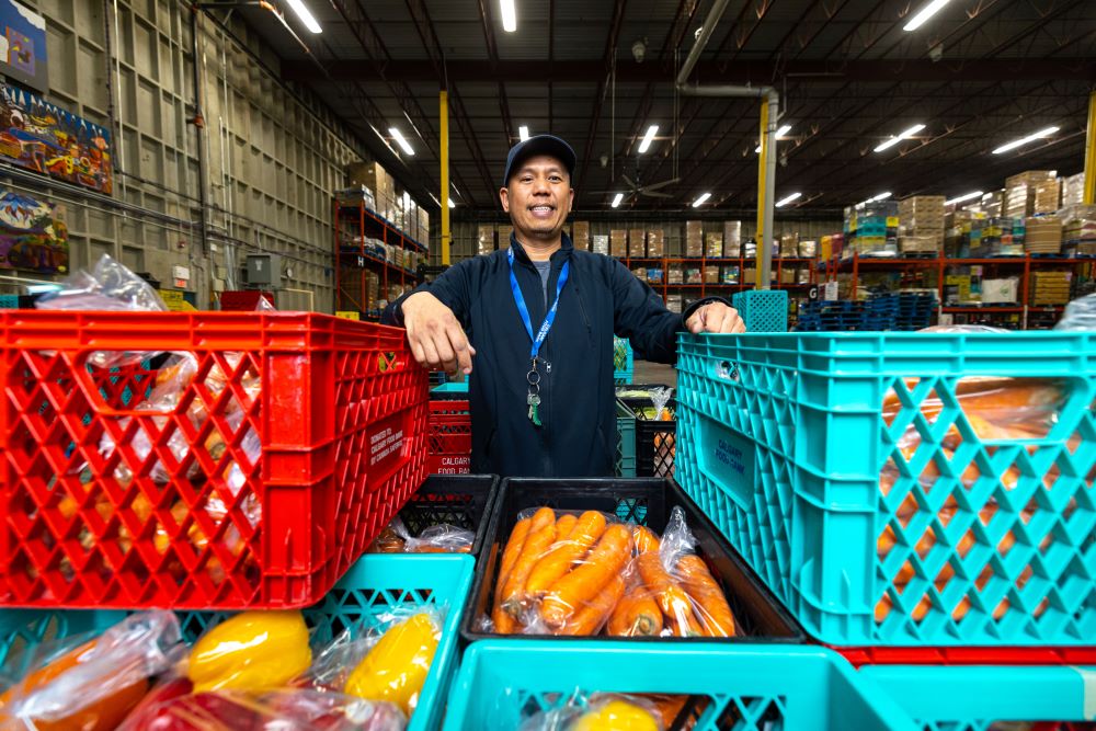 Calgary Food Bank staff with crates of fresh vegetables